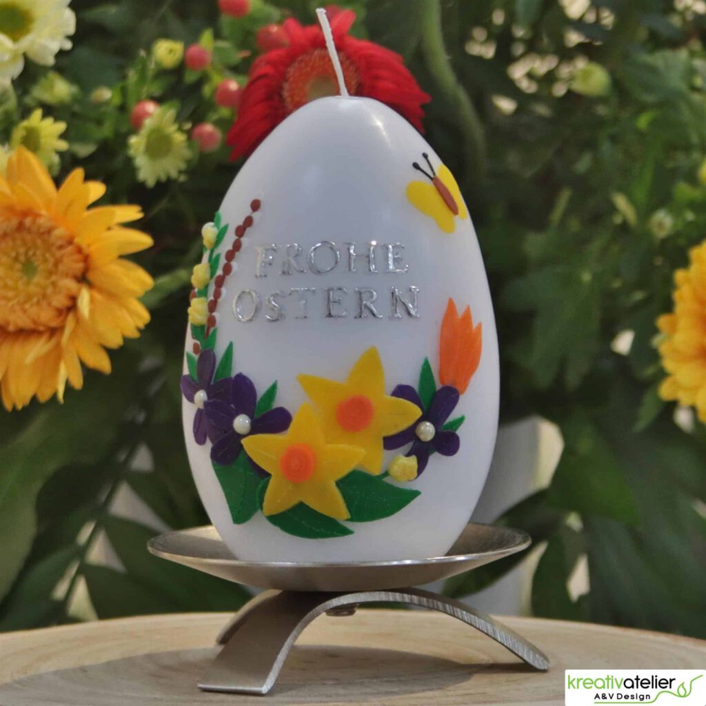 grosse, weisse Ostereikerze mit Fruehlingsstrauss, Schmetterling und Frohe Ostern