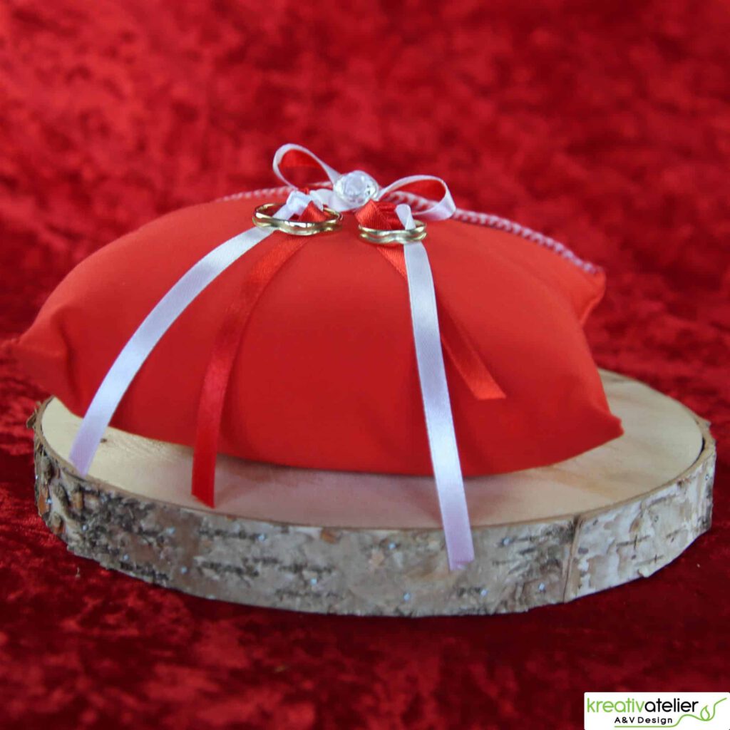 Ringkissen aus rotem Poppeline mit Satinbaendern