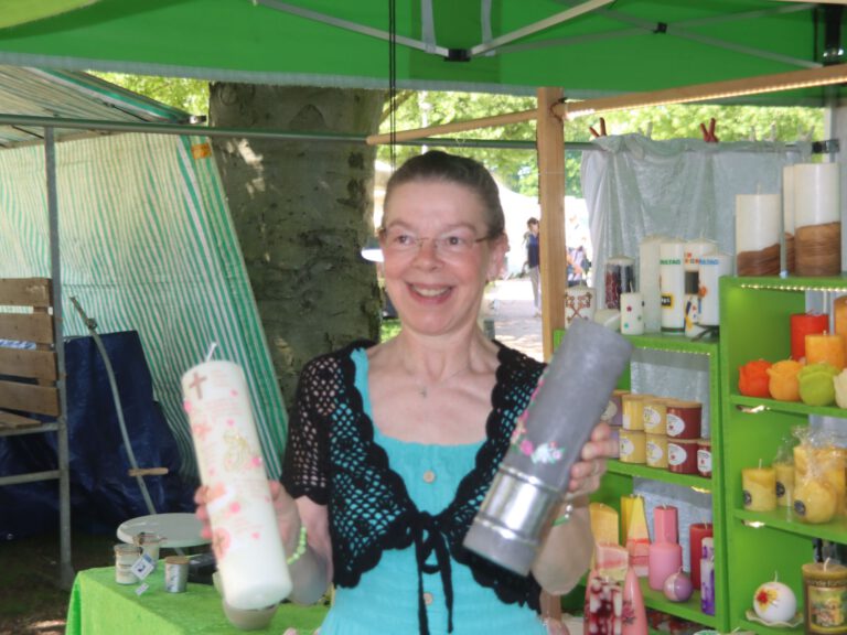 Angela Barbian präsentiert handverzierte Kerzen am Marktstand auf dem Flachsmarkt 2026 auf Burg Linn