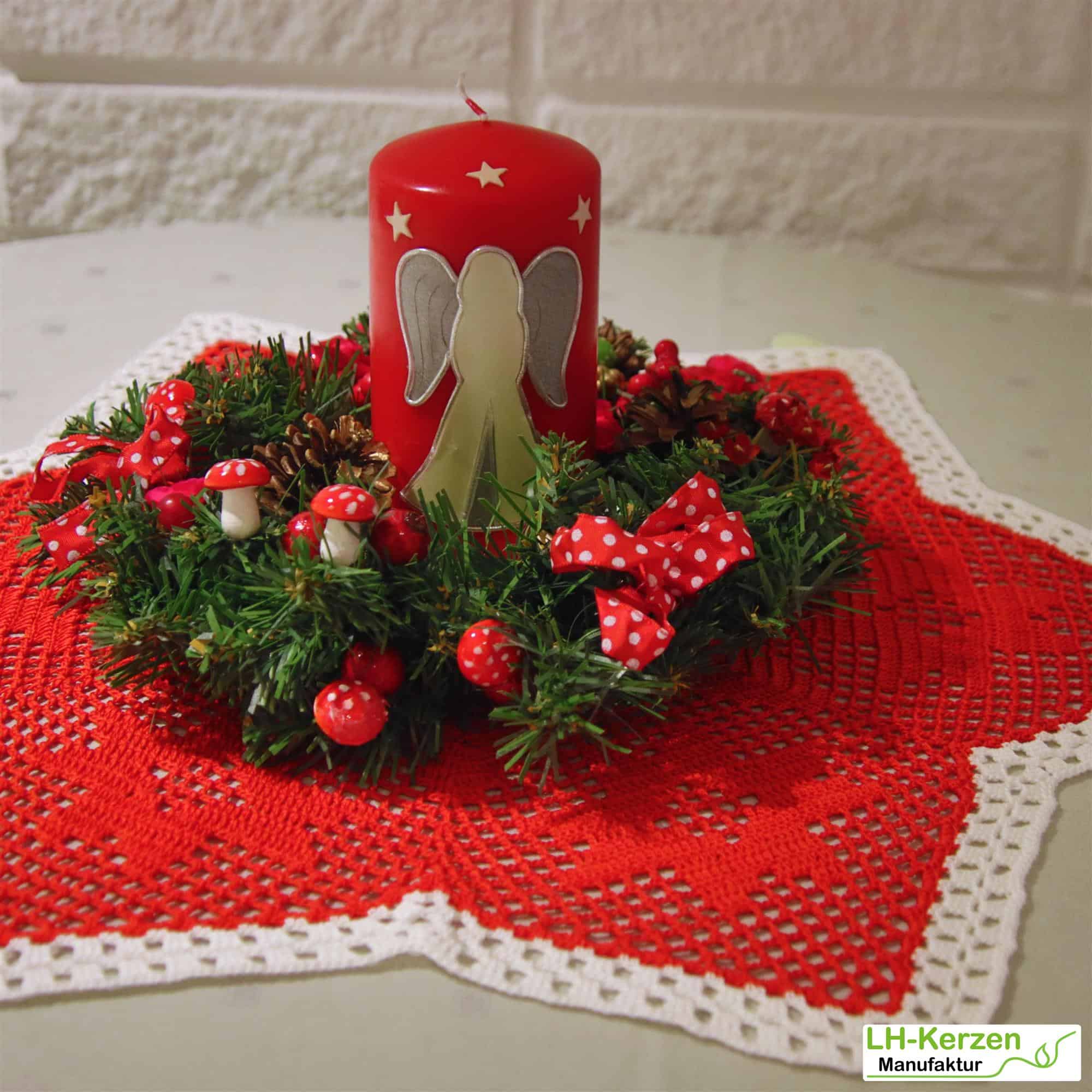Rote Weihnachtskerze mit stehendem Engel