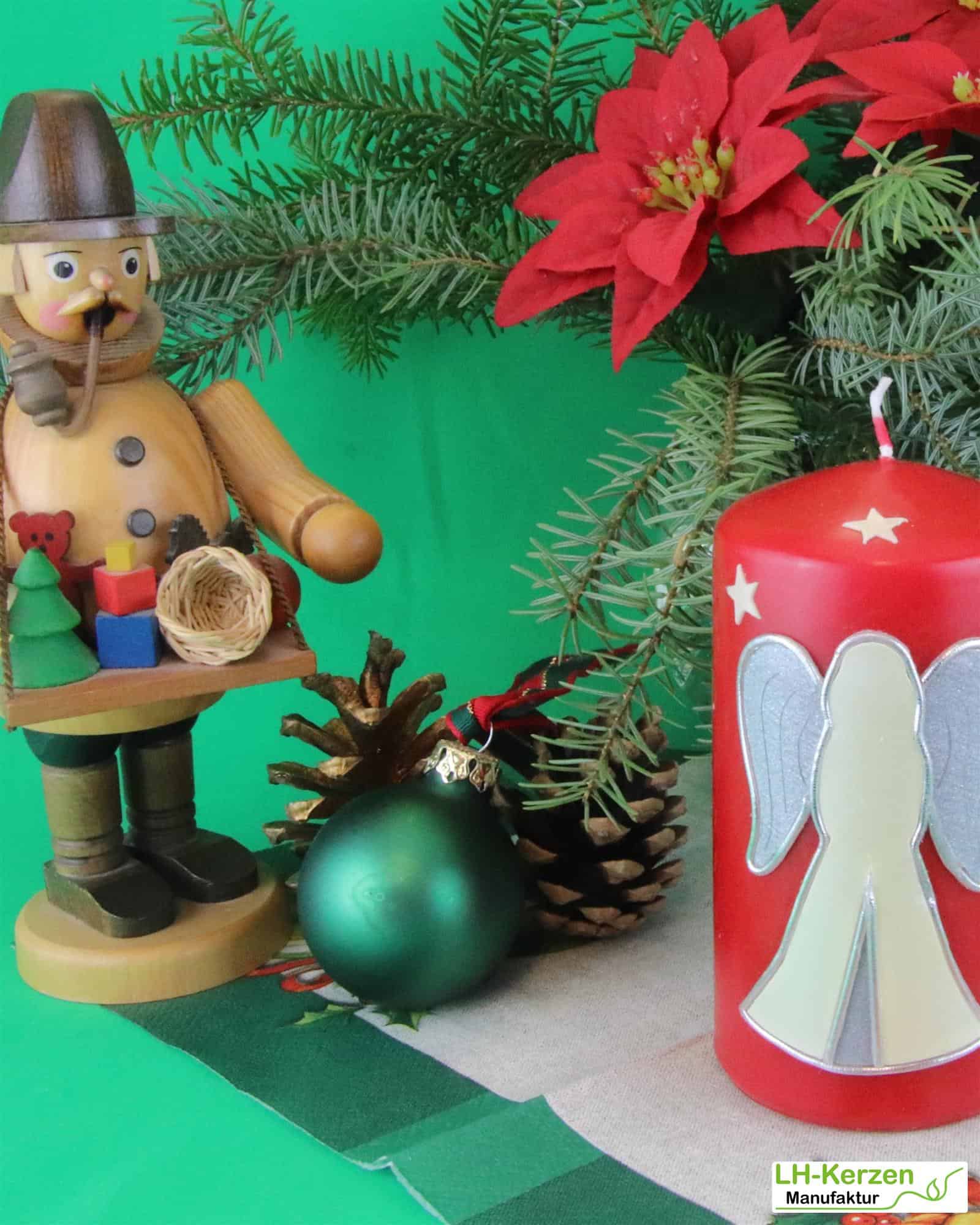 Rote Weihnachtskerze mit stehendem Engel