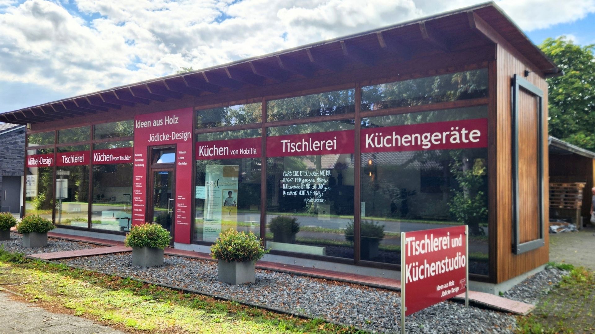 Gebäude von Jödicke Design mit Schaufenstern und Beschriftungen für Tischlerei und Küchenstudio